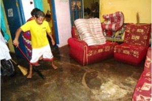 Pemilik rumah di Sawahwaru tampak sibuk memngeluarkan meubeul dan air yang merendam rumahnya.